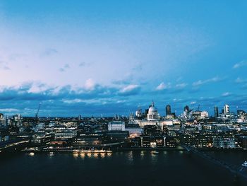 River amidst buildings in city against sky