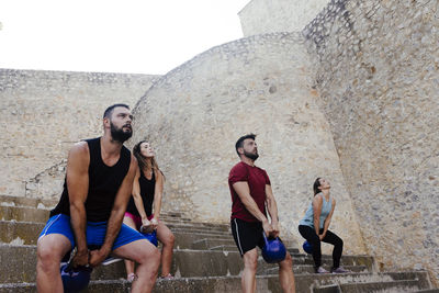 Athletes lifting a kettelbell crossfit weights in an urban enviroment.