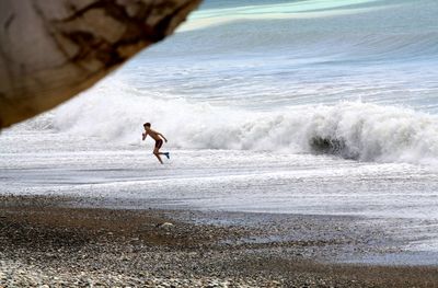 Man surfing on sea shore