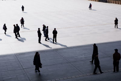 High angle view of people walking on snow