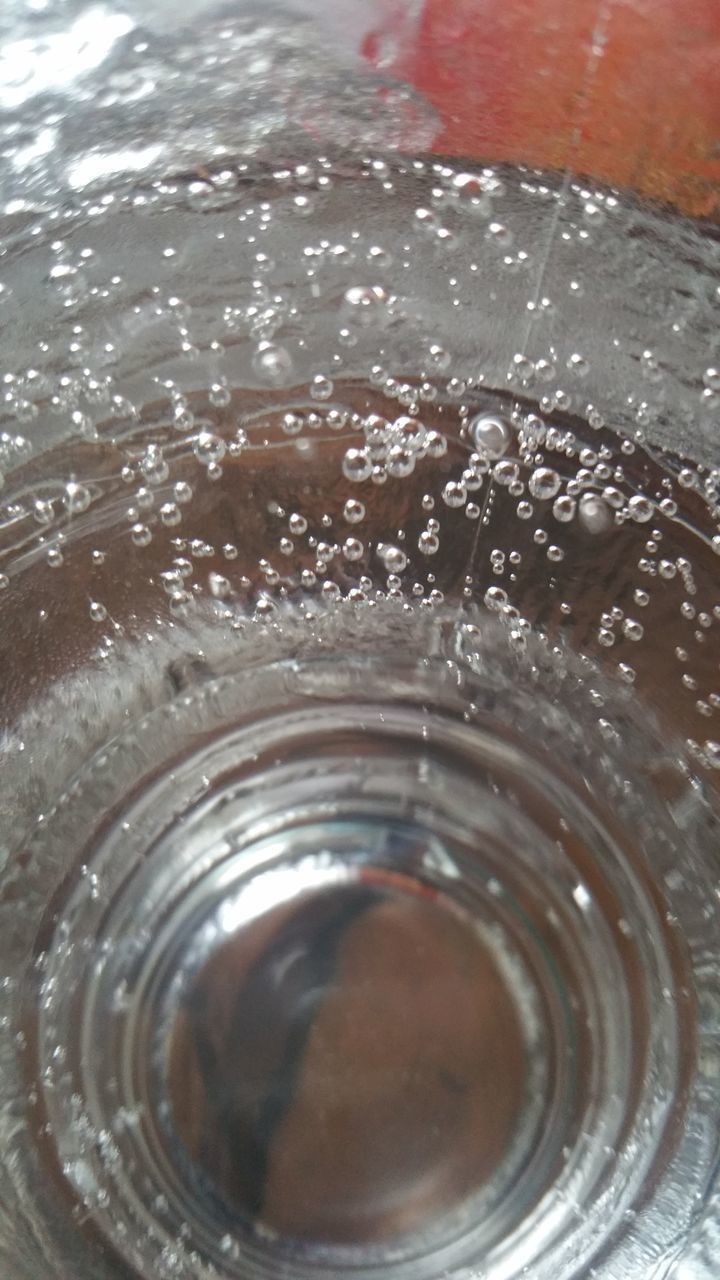 indoors, close-up, circle, glass - material, transparent, reflection, no people, refreshment, drink, pattern, glass, shiny, geometric shape, technology, low angle view, part of, day, detail, focus on foreground, window