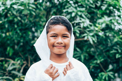 Portrait of smiling boy wearing white raincoat