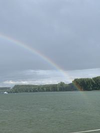 Scenic view of rainbow over trees against sky