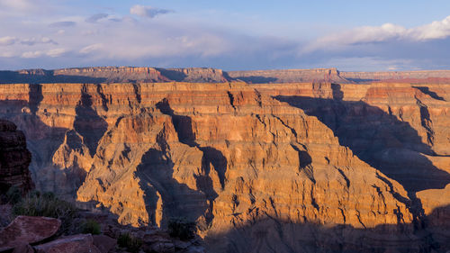 Rock formations on landscape against cloudy sky