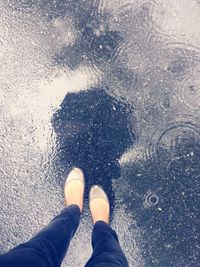 Low section of man standing on puddle