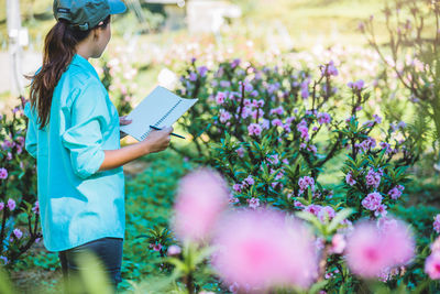 Female researcher examining flowers on land