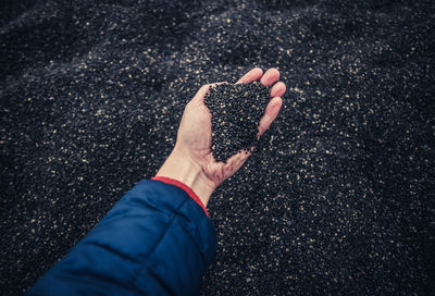 Midsection of person holding umbrella on road