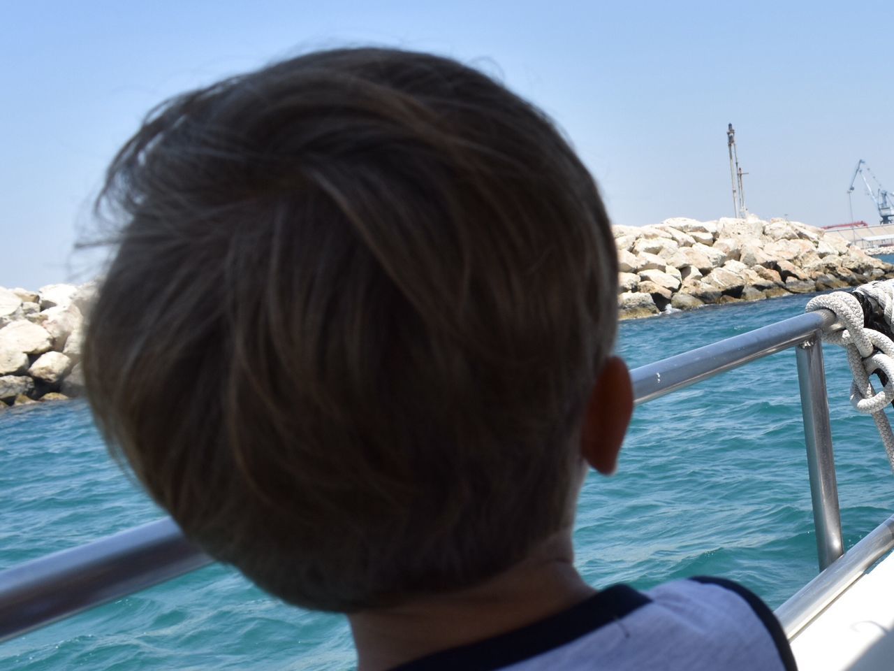 rear view, real people, sea, headshot, one person, transportation, day, nautical vessel, water, outdoors, childhood, clear sky, vacations, men, nature, close-up, sky