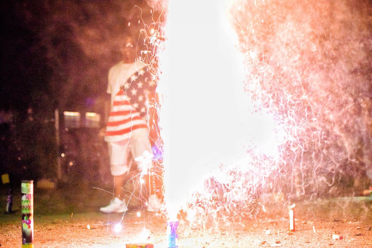 night, one person, outdoors, firework - man made object, patriotism, people, motion, sparkler, spraying, city, men, adult, adults only, sky, one man only, close-up, only men, human hand