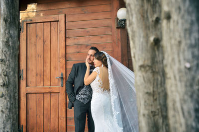 Wedding couple standing by built structure