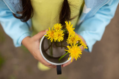 Midsection of woman holding flower