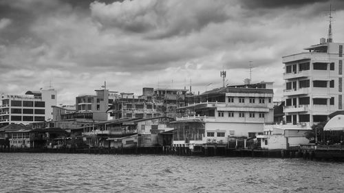 Buildings by sea against sky in city