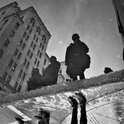 Low section of people standing puddle with reflection