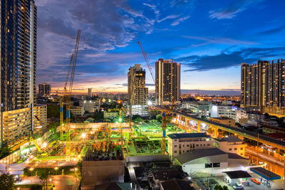 High angle view of illuminated buildings against sky at dusk