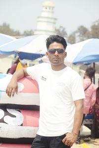 Portrait of young man standing against sky