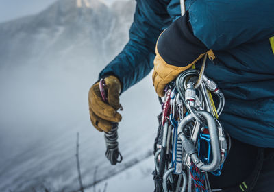 A man sorts through rock and ice climbing gear during a winter climb