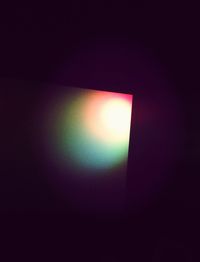 Low angle view of illuminated lamp in darkroom