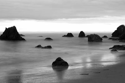 Rocks in sea against sky