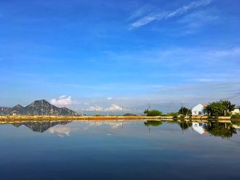 Reflection of trees in lake against blue sky