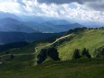 Scenic view of valley and mountains against cloudy sky