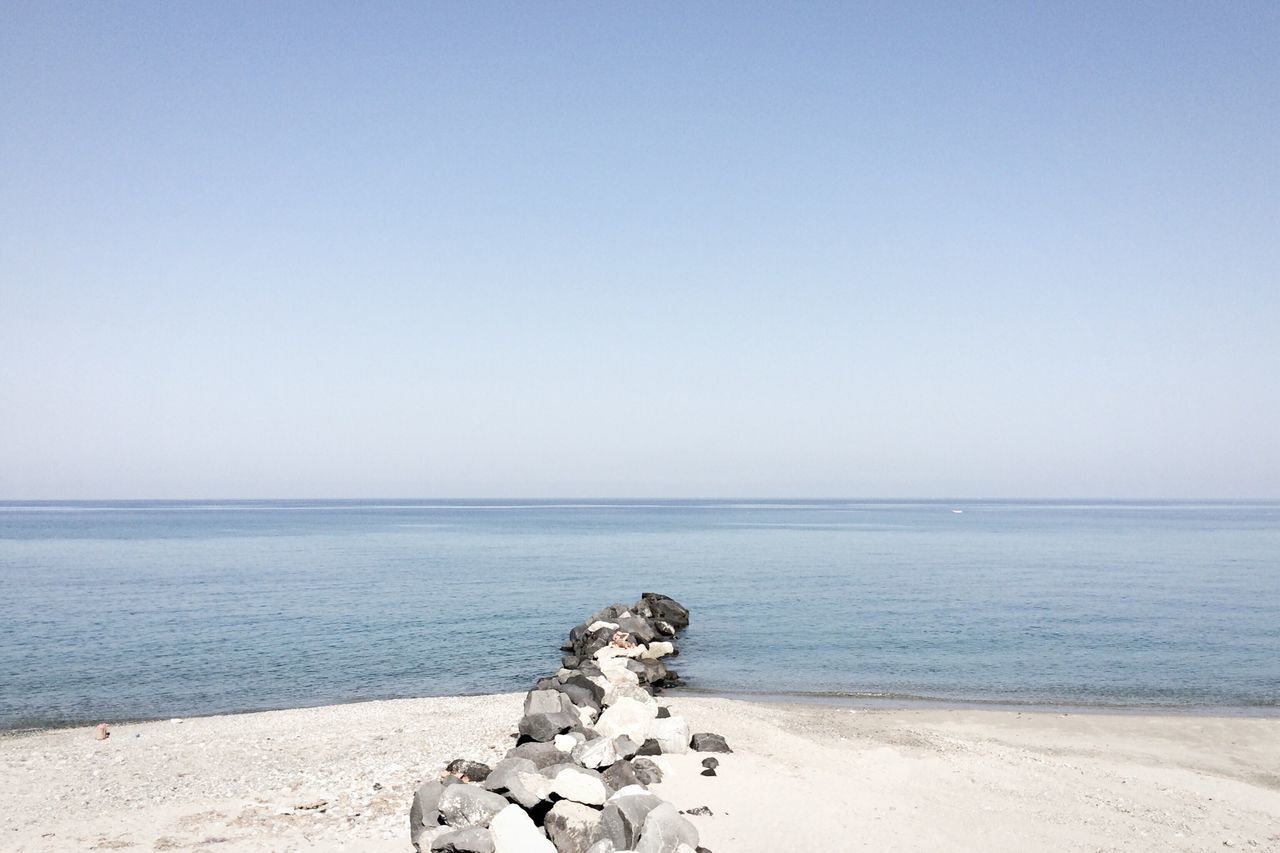 sea, horizon over water, clear sky, copy space, beach, water, tranquil scene, tranquility, shore, scenics, beauty in nature, nature, sand, idyllic, rock - object, blue, coastline, remote, day, outdoors