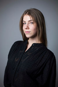 Portrait of beautiful young woman against gray background