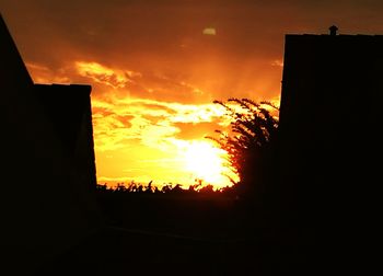 Silhouette of building against cloudy sky