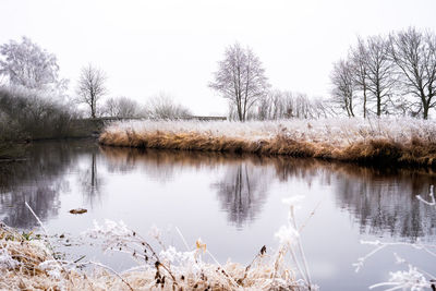 Scenic view of lake against sky during winter