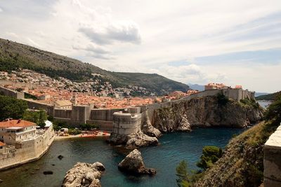 Buildings by sea against sky