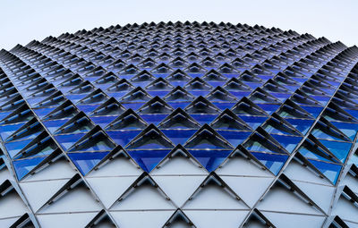 Low angle view of modern building against blue sky