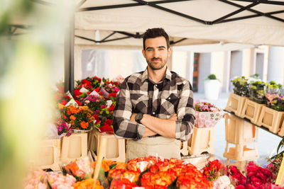 Portrait of confident male owner standing arms crossed in flower shop