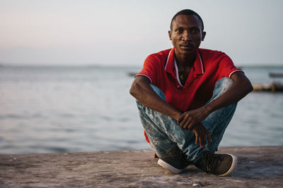 Portrait of young man sitting on beach