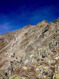 Low angle view of mountain against blue sky