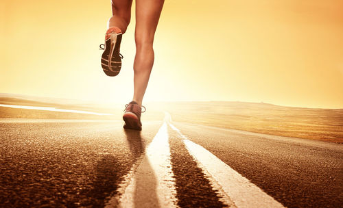 Low section of woman running on road