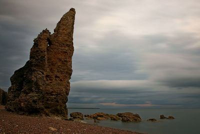 Rock formation on sea against sky