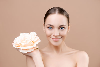 Portrait of young woman holding rose