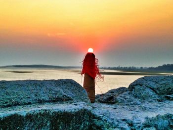 Rear view of woman standing in lake