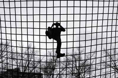 Low angle view of silhouette boy against sky