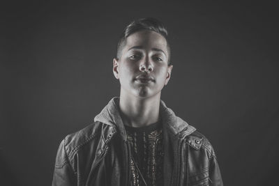 Portrait of young man against black background