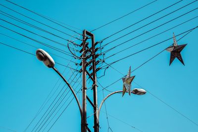 Low angle view of telephone line against clear blue sky