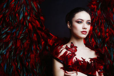 Beautiful woman with angel wings against black background