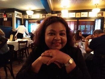 Portrait of a smiling young woman sitting at restaurant