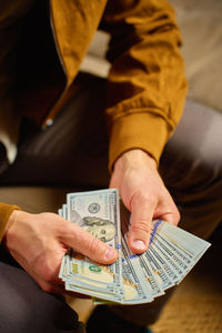 Midsection of man holding paper currency