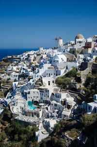 High angle view of residential buildings against blue sky