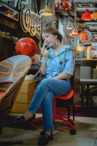 Full length of young woman sitting on chair