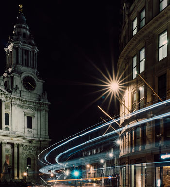 LOW ANGLE VIEW OF ILLUMINATED BUILDINGS AGAINST SKY AT NIGHT