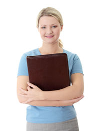 Portrait of a smiling young woman standing against white background
