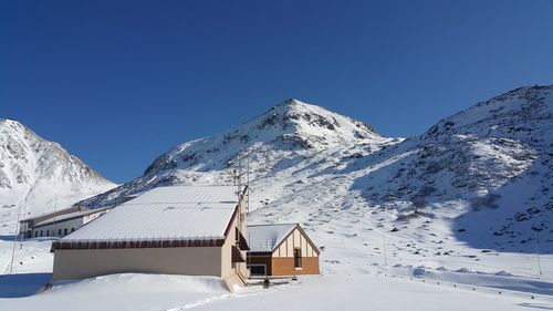 Scenic view of snowcapped mountains against clear blue sky