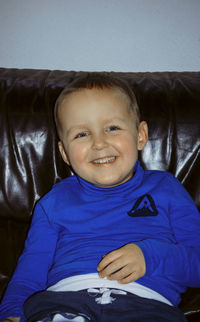 Portrait of boy sitting on sofa at home