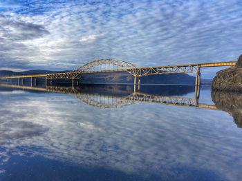 Reflection of interstate bridge and wispy clouds on calm river